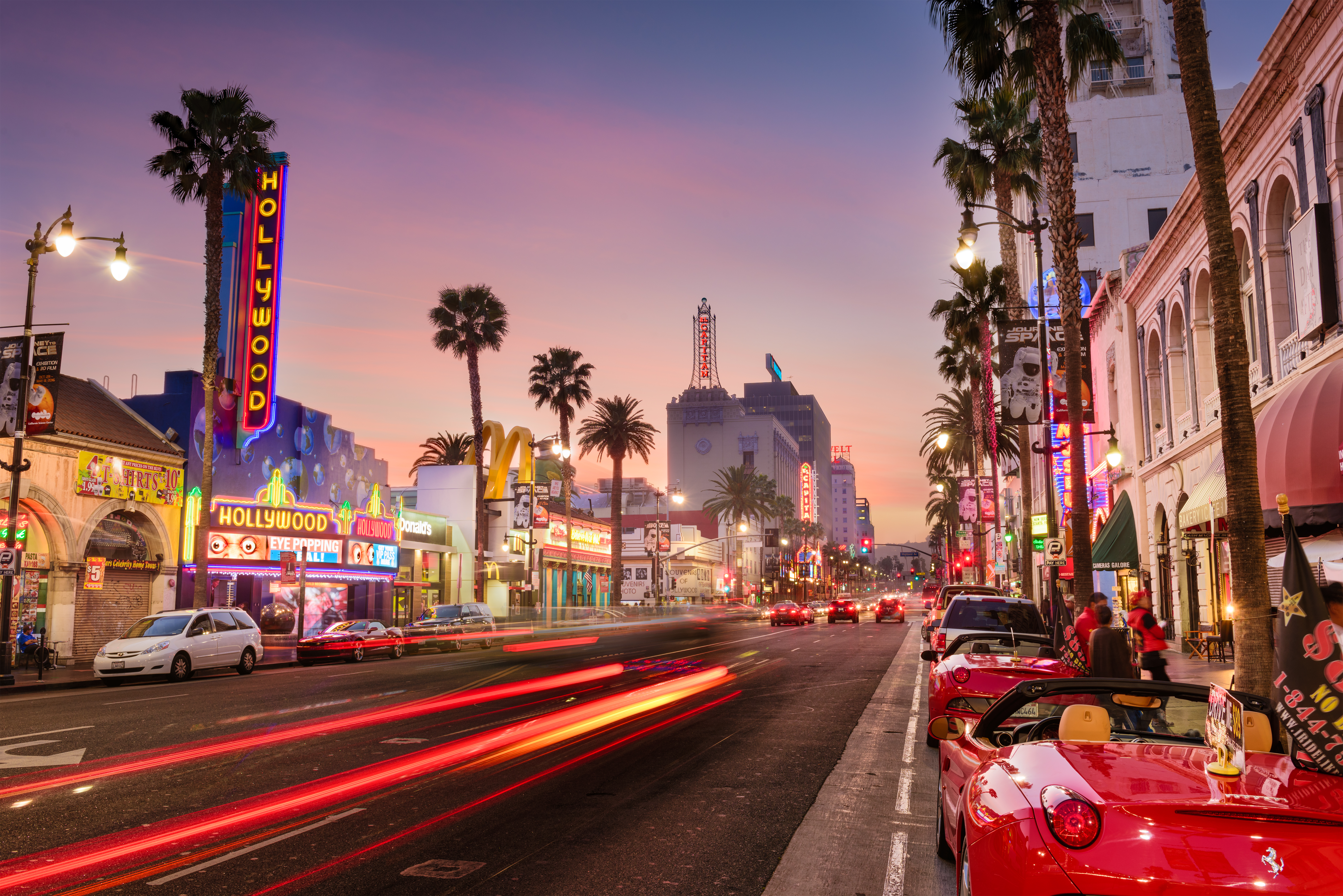 Downtown Los Angeles at dusk with cars moving along the road