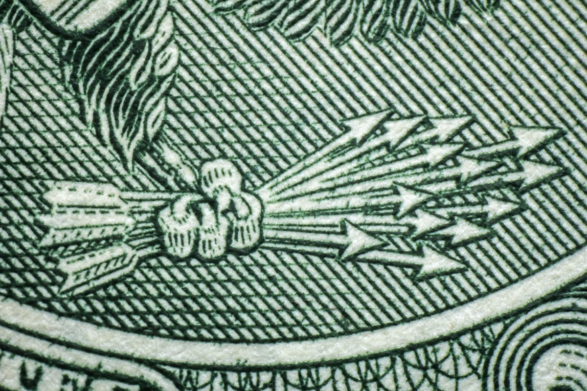 Macro closeup American currency dollar eagle claw holding arrows