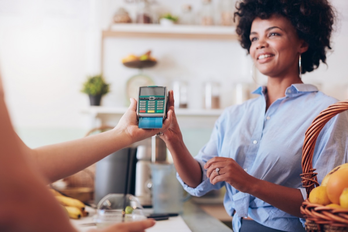 woman paying with card, never say to cashier