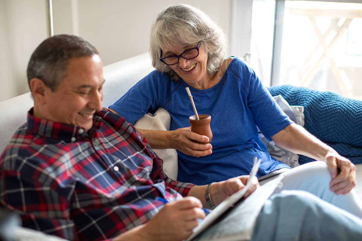 Older couple relaxing on couch doing a crossword