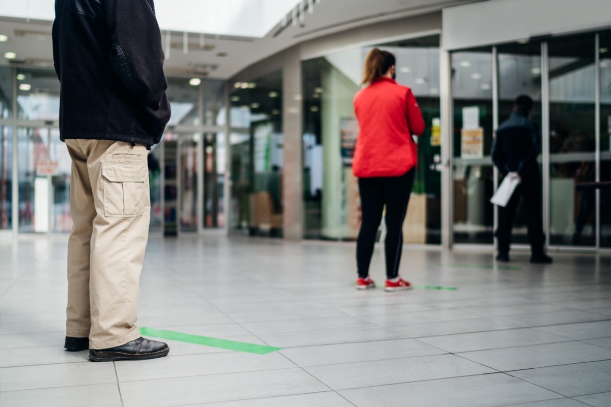 People standing in line front of bank/store due to coronavirus pandemic safety guideline