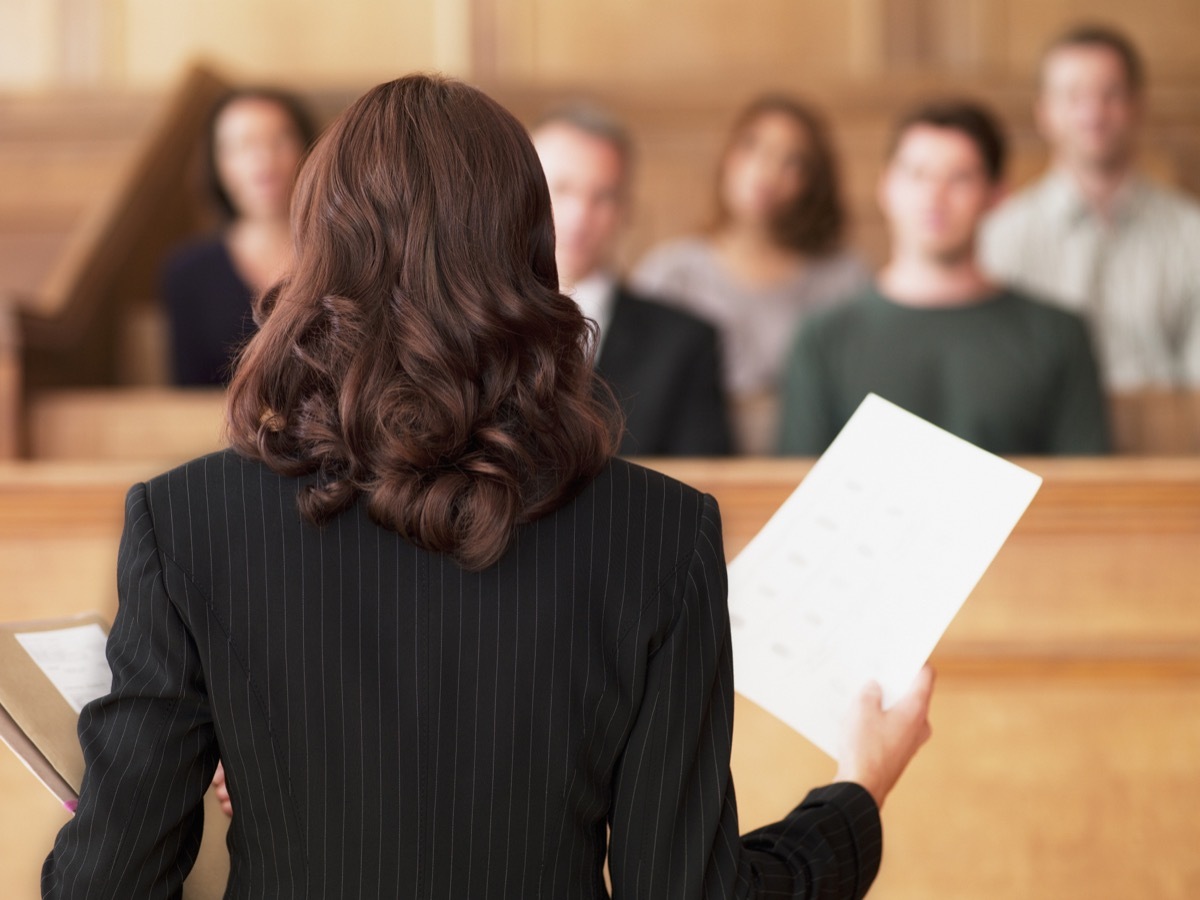 jury duty selection behind a lawyer holding up papers