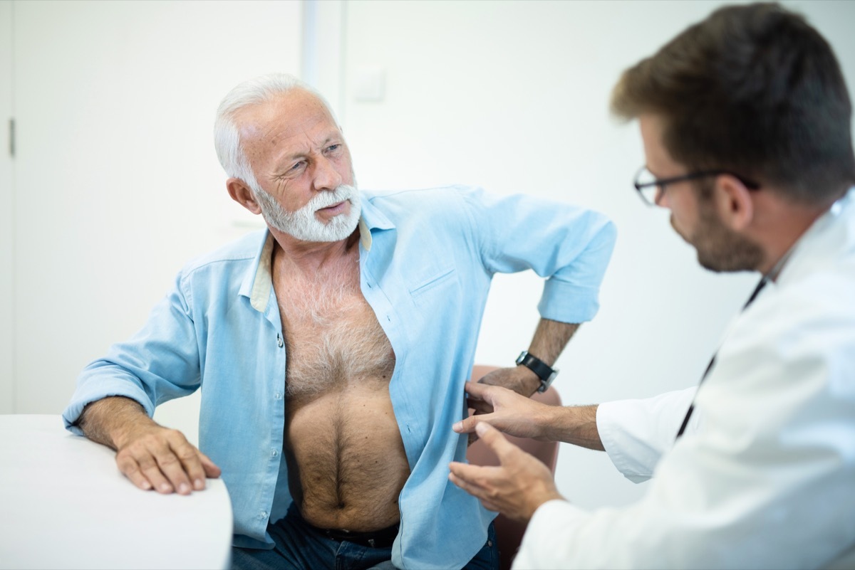 Senior man with a painful back-kidney on a medical exam.