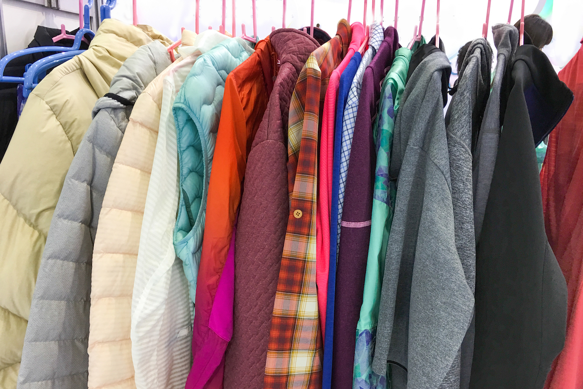 Colorful coats, jackets, and hoodies hanging in closet