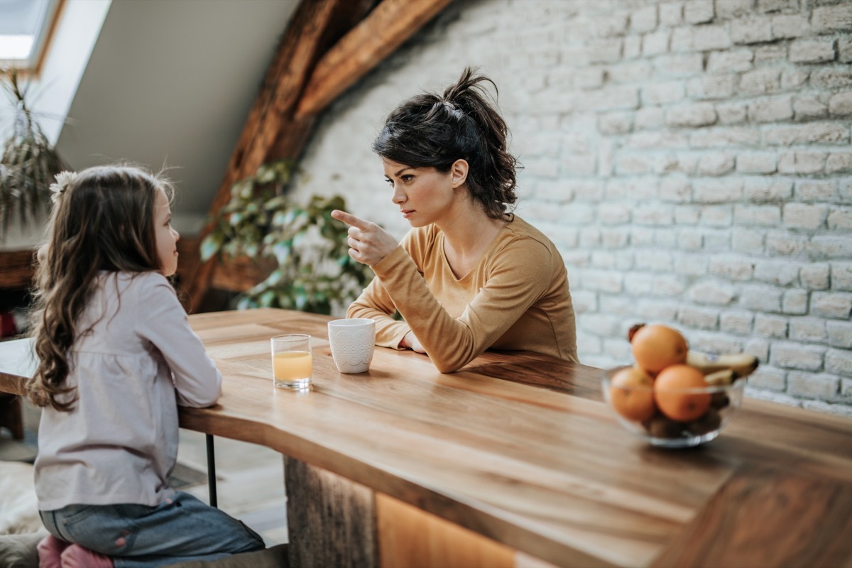 mother yelling at her daughter over the kitchen table