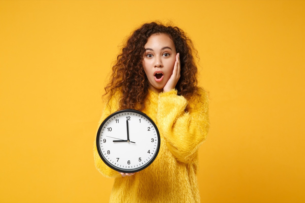 Woman holding clock. 