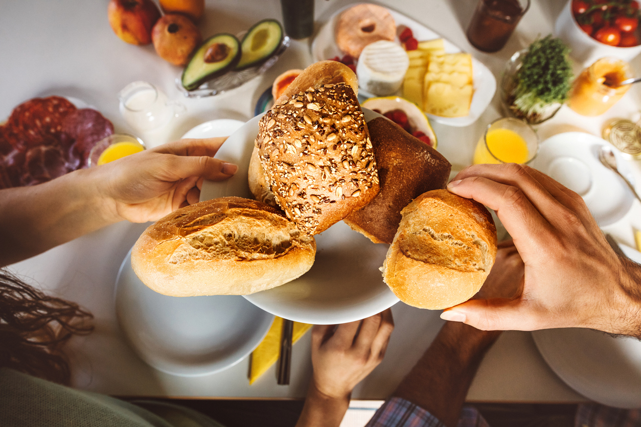 An overhead shot of a bread plate at a breakfast table