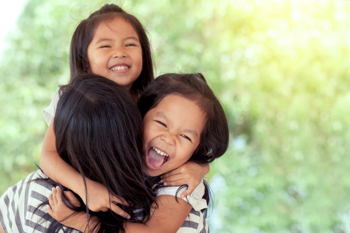 twin girls hugging their mother