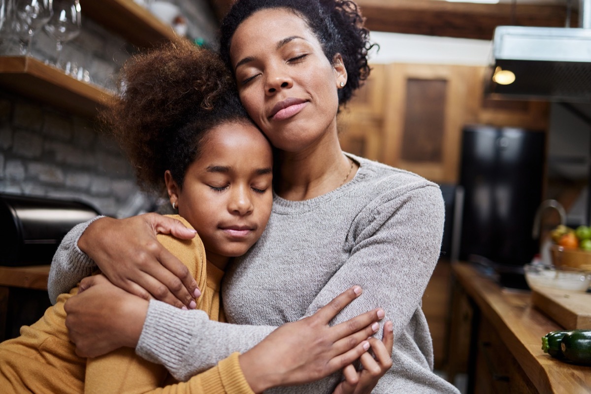 mother embracing her little daughter at home.