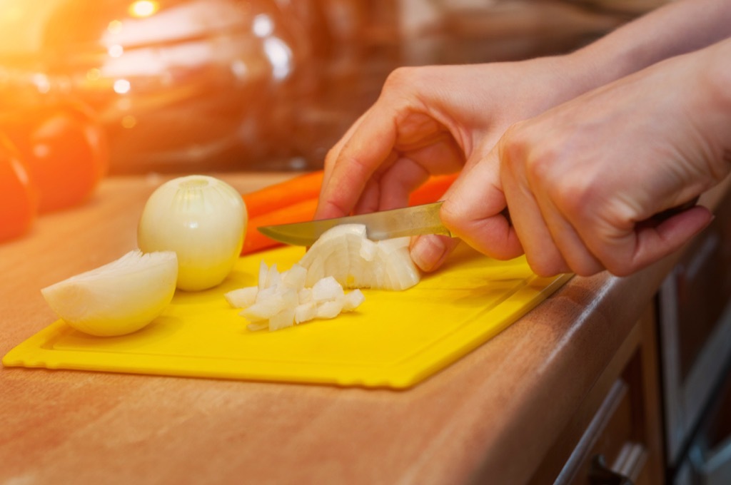 chopping onions on a plastic cutting board