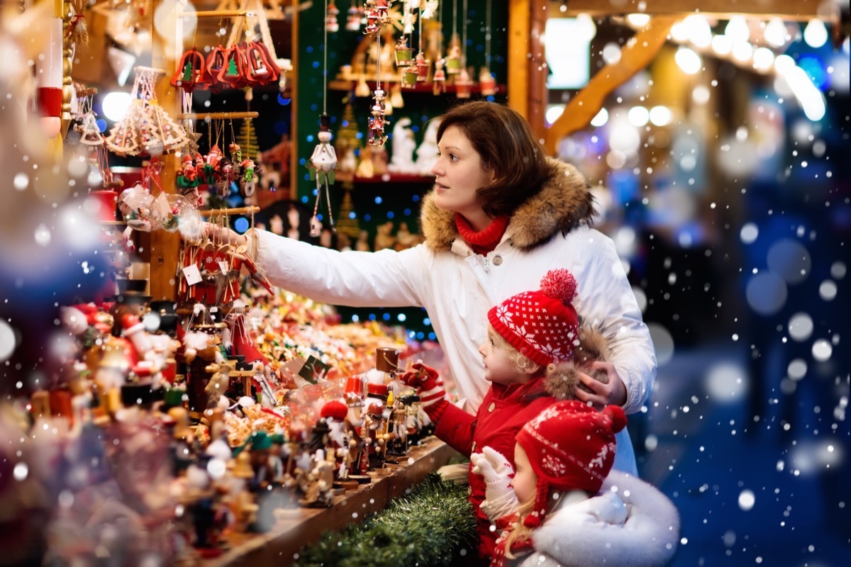 Woman and two young girls shopping for ornaments at holiday market