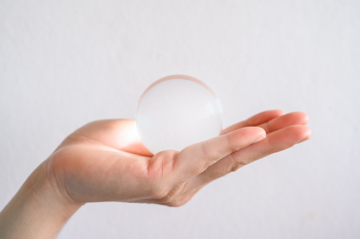 hand holding a clear transparent Crystal ball