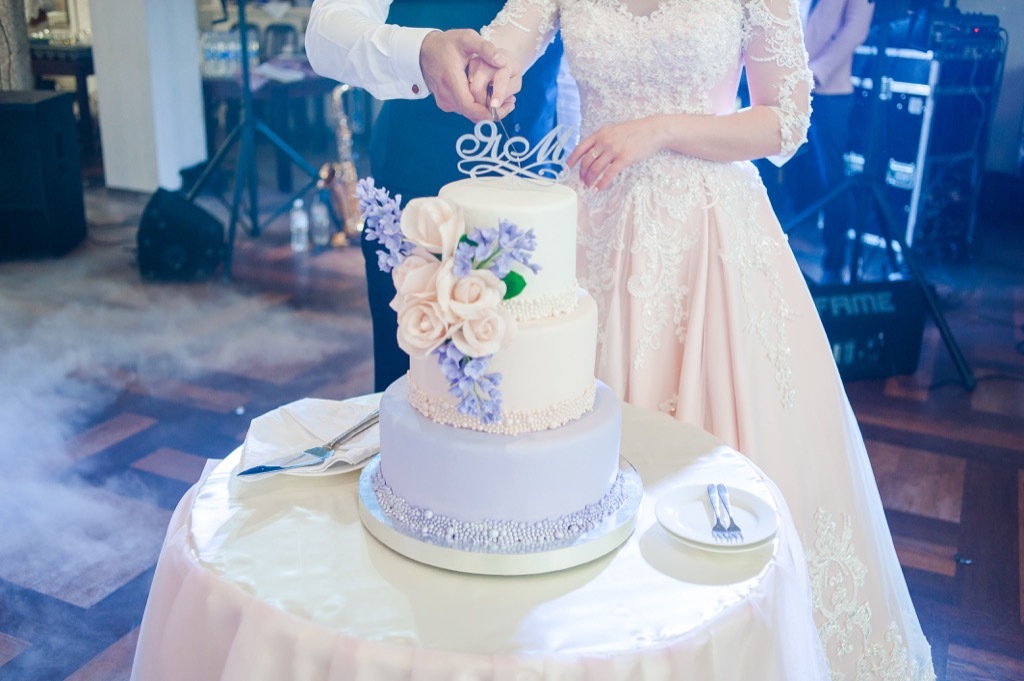 bride and groom cutting wedding cake this is the age most people get married in every US state