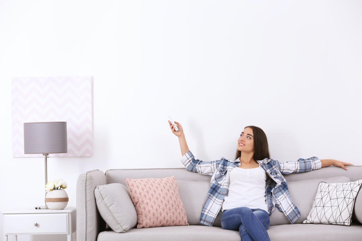 Woman turning on air conditioner