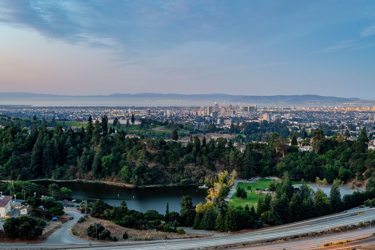 The sun rises over San Francisco, Oakland, and the rest of the bay, while filling the cloudy sky with vibrant color.