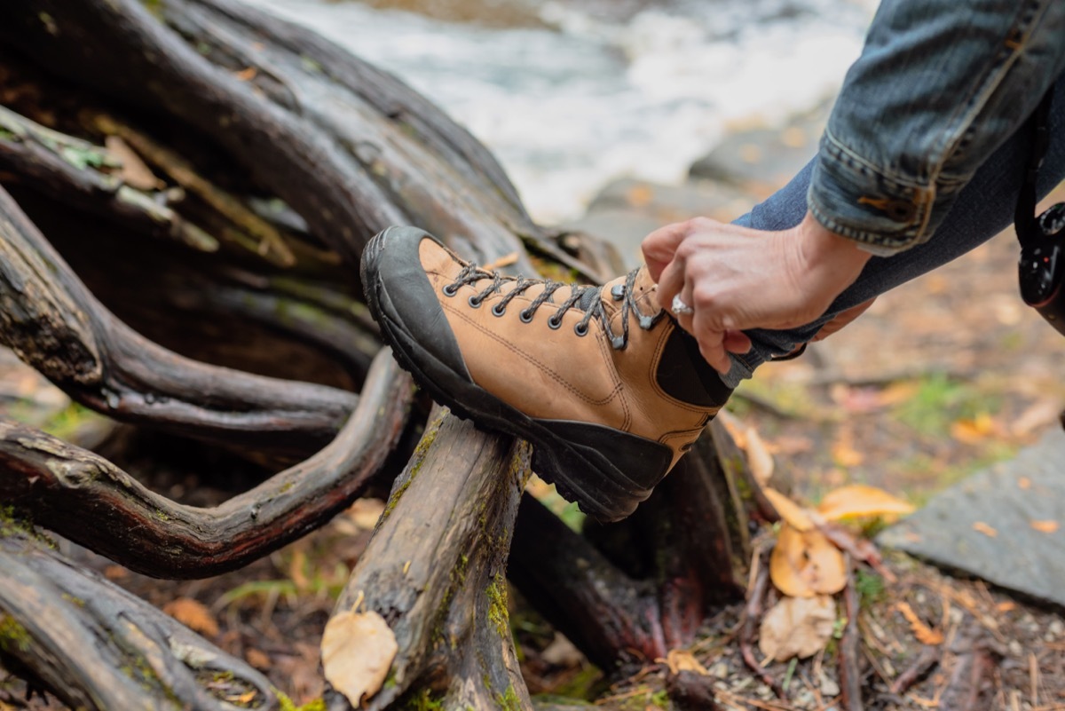 person tucking pants into hiking boots