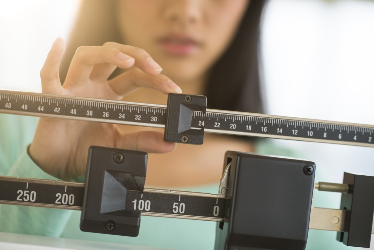 Woman weighing herself on scale