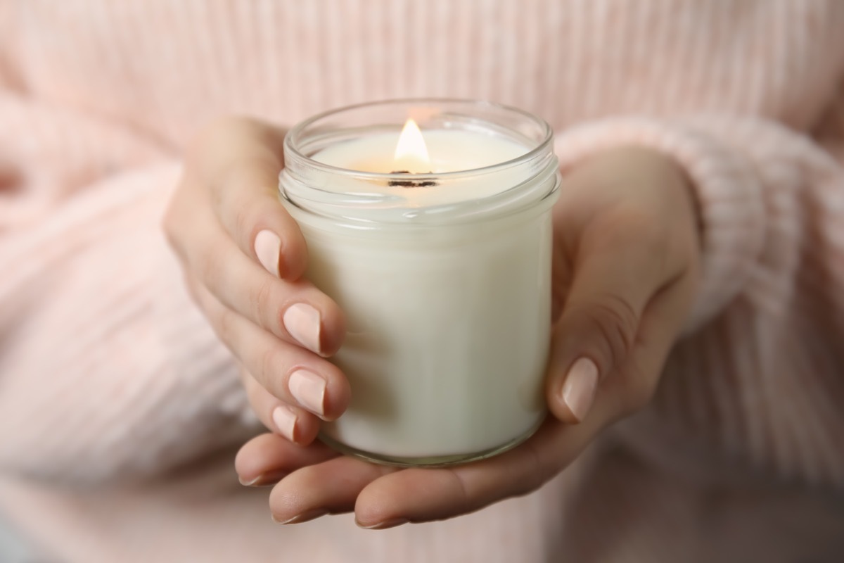 Woman holding a white candle.