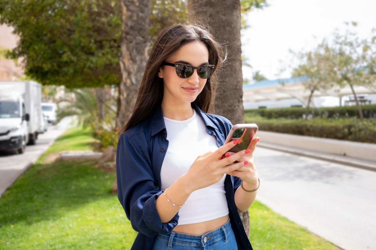 woman texting wearing navy linen shirt