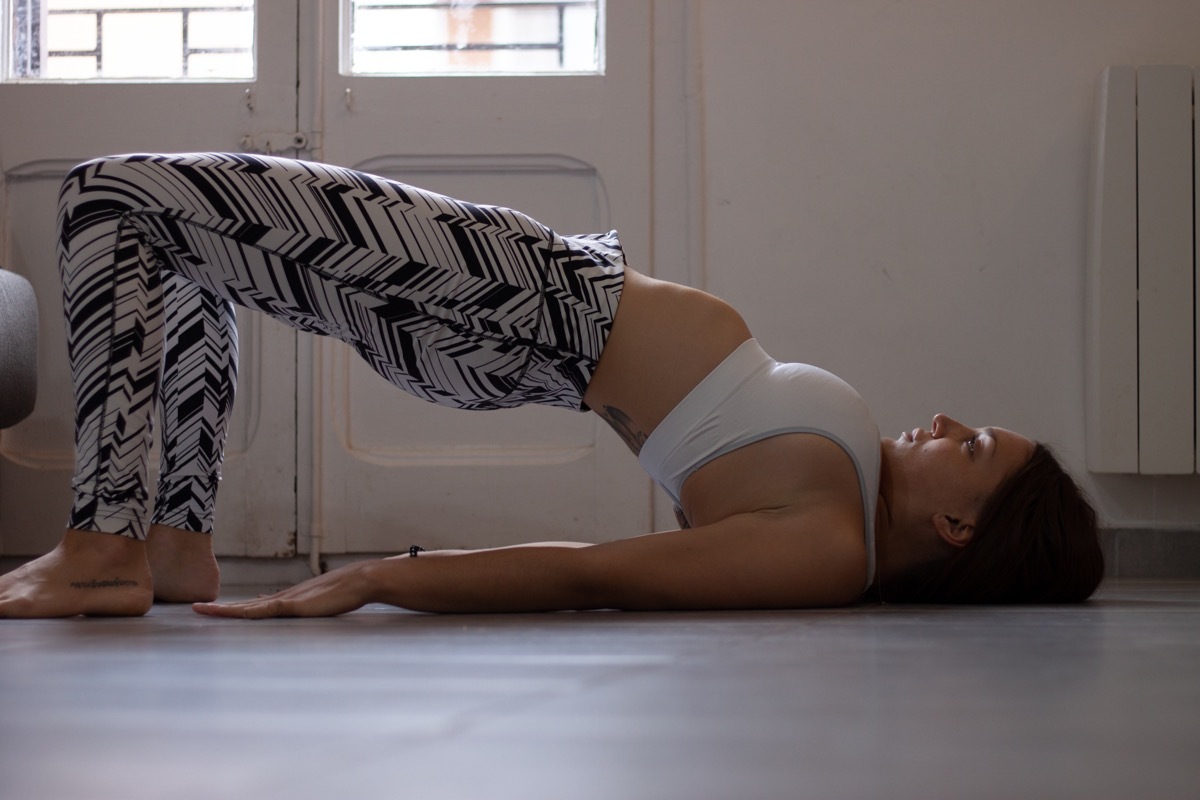 Woman doing glute bridge with walk-out and sit-up