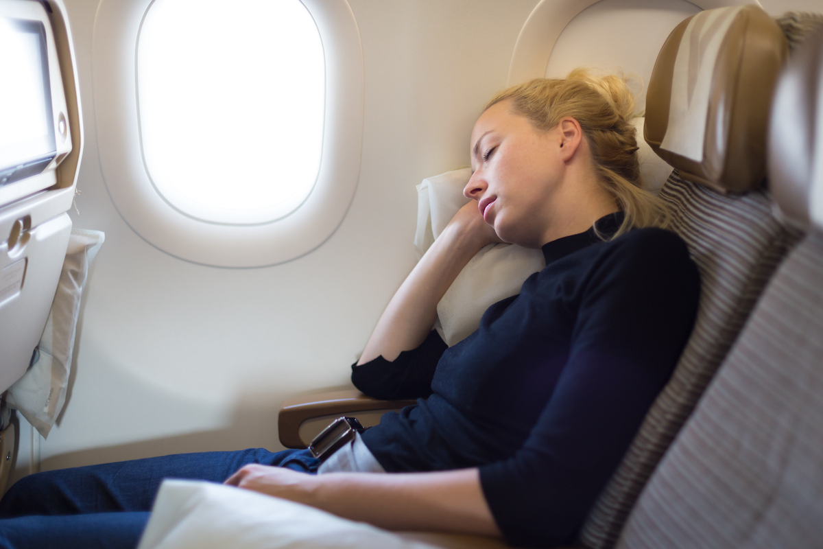 A woman sleeping on an airplane.