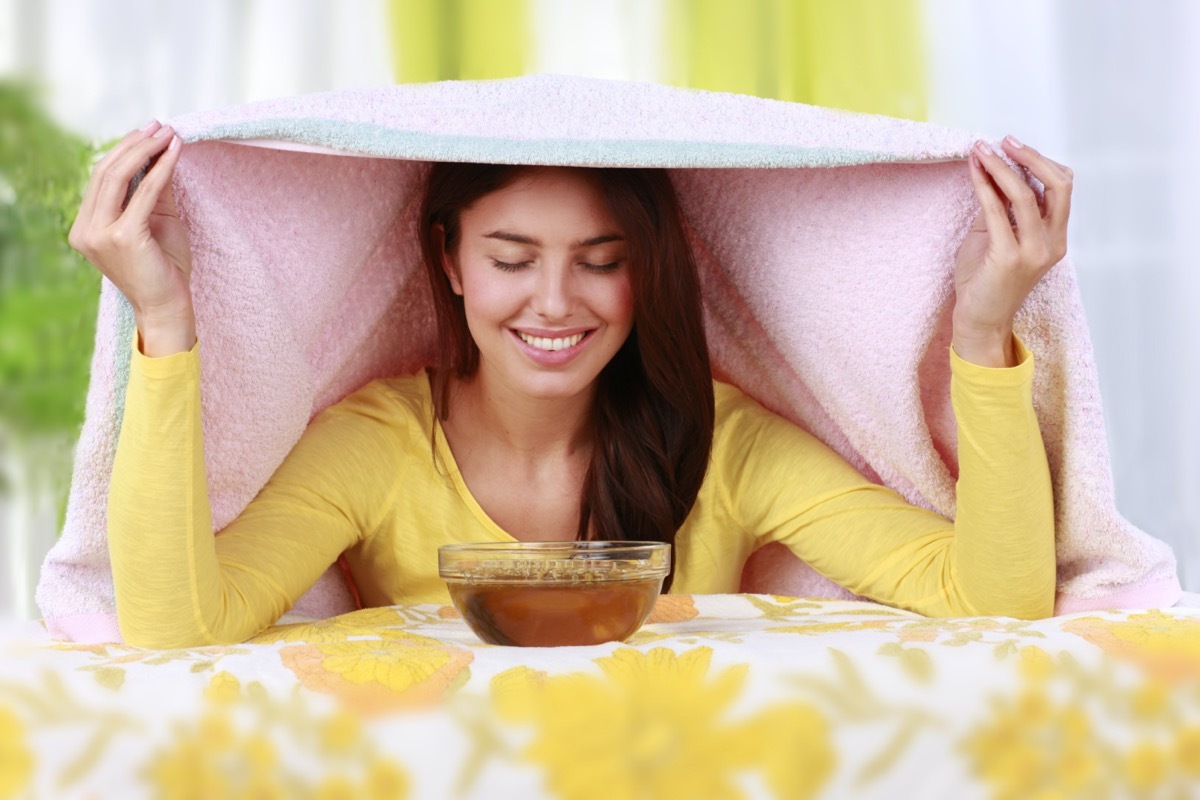 Woman inhales steam to treat a blocked nose