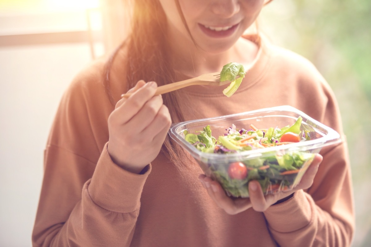 young woman eating salad