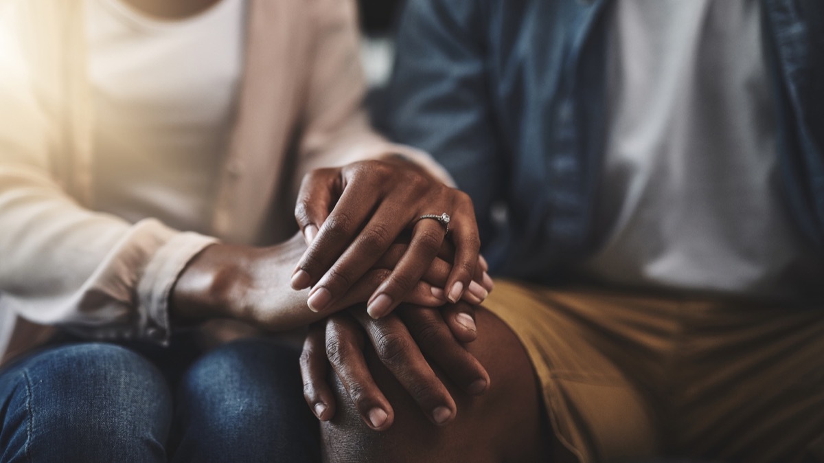 close up of black married couple holding hands